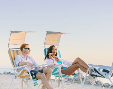 Two people sitting in SUNFLOW beach chairs on the beach