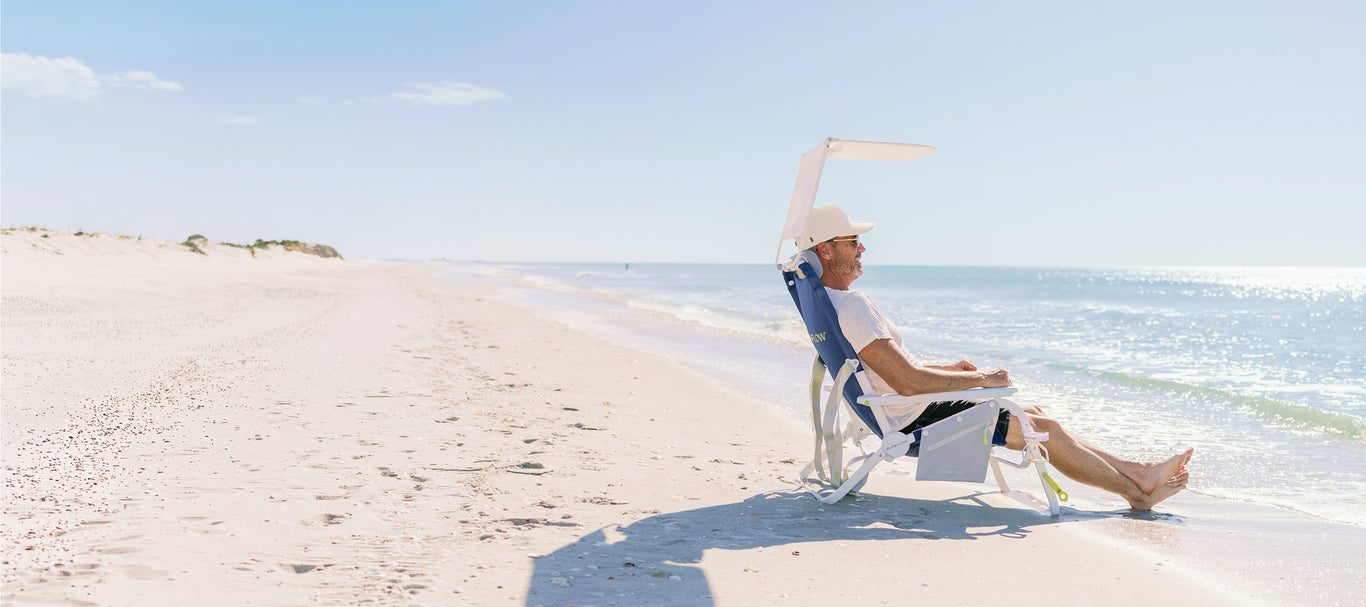 Man sitting in Sunflow chair non beach near waves